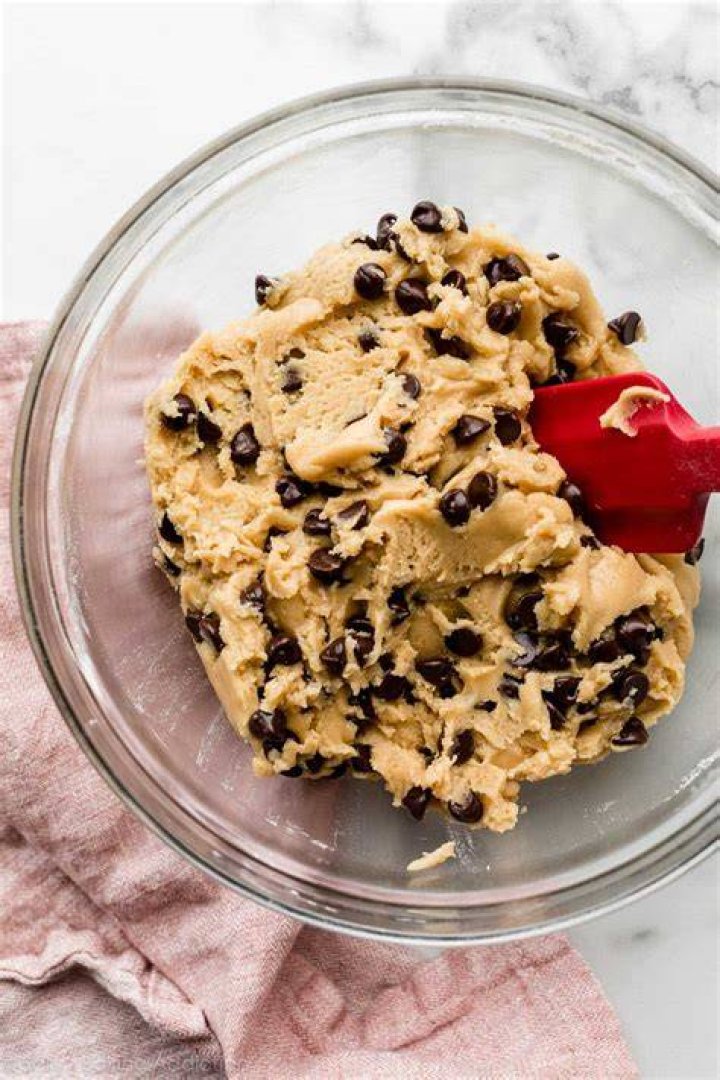 Chocolate chip cookie dough in a glass mixing bowl.