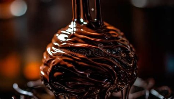 Glass bowl over a chocolate chip cookie on a baking sheet,
