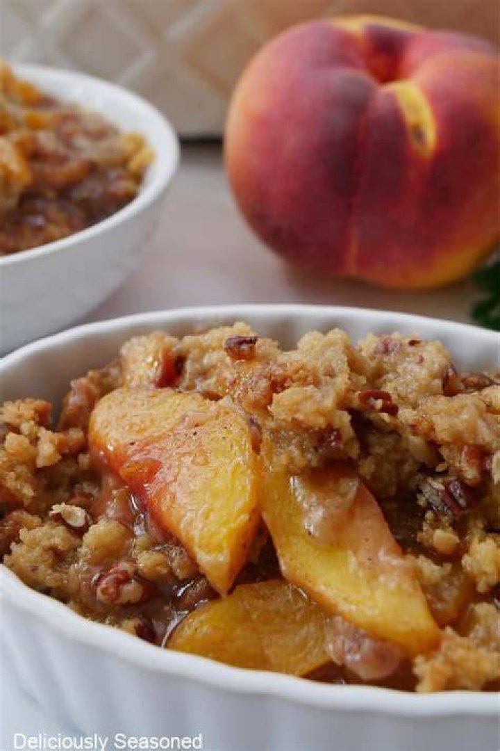 Peach crisp in a white and blue casserole dish.