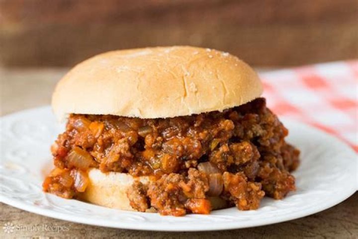 Sloppy joe sandwich on a plate with pickles